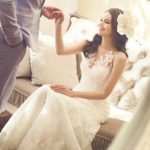 美しい花嫁の画像です。花婿がソファから立ち上がる花嫁の手をとっています