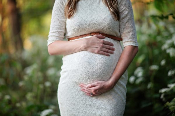 妊娠中の妊婦が森のなかでたたずむ画像